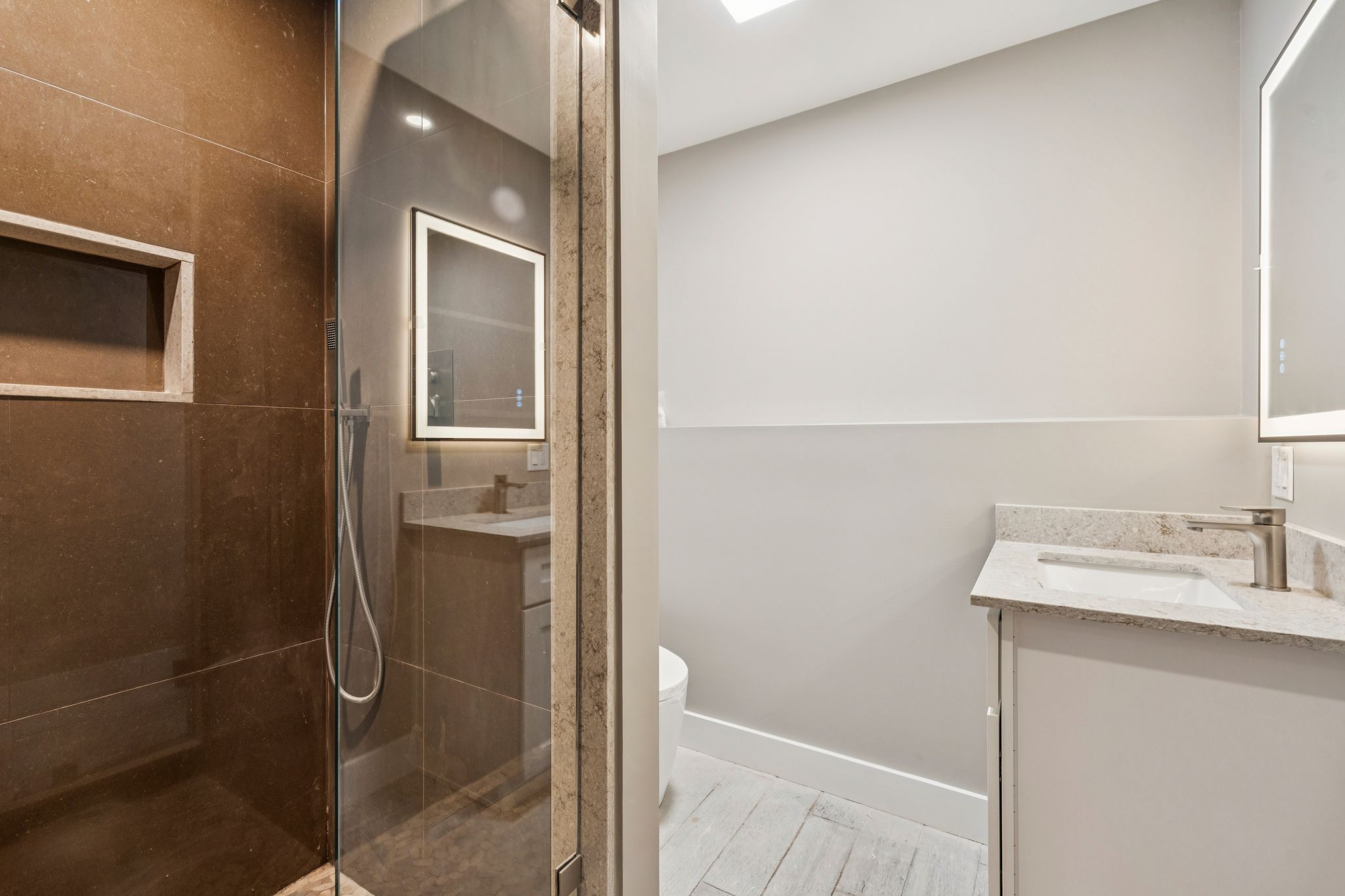 Living room fireplace with black marble surround, white built-in shelves, and decorative items including a carved wood boat and framed photos.