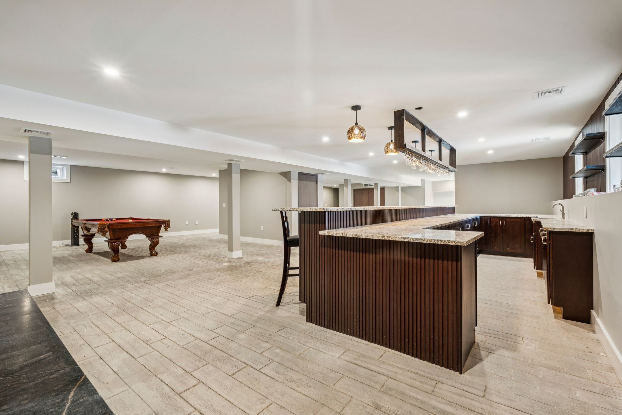 Living room with a fireplace, large windows showing a snowy outdoor landscape, and a wooden dining table with eight chairs.