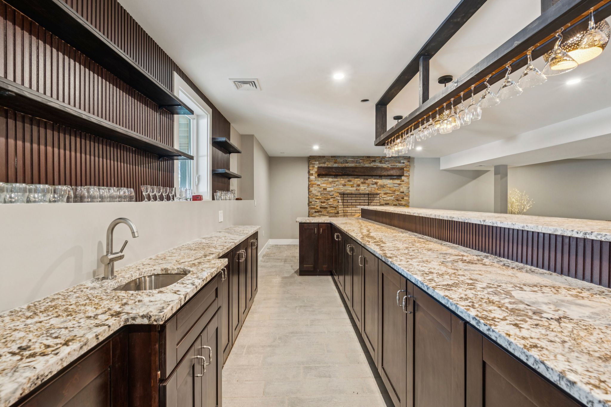 Spacious living room with large windows, sectional sofa, armchair, wooden coffee tables, dining table with chairs, and decorative artwork.