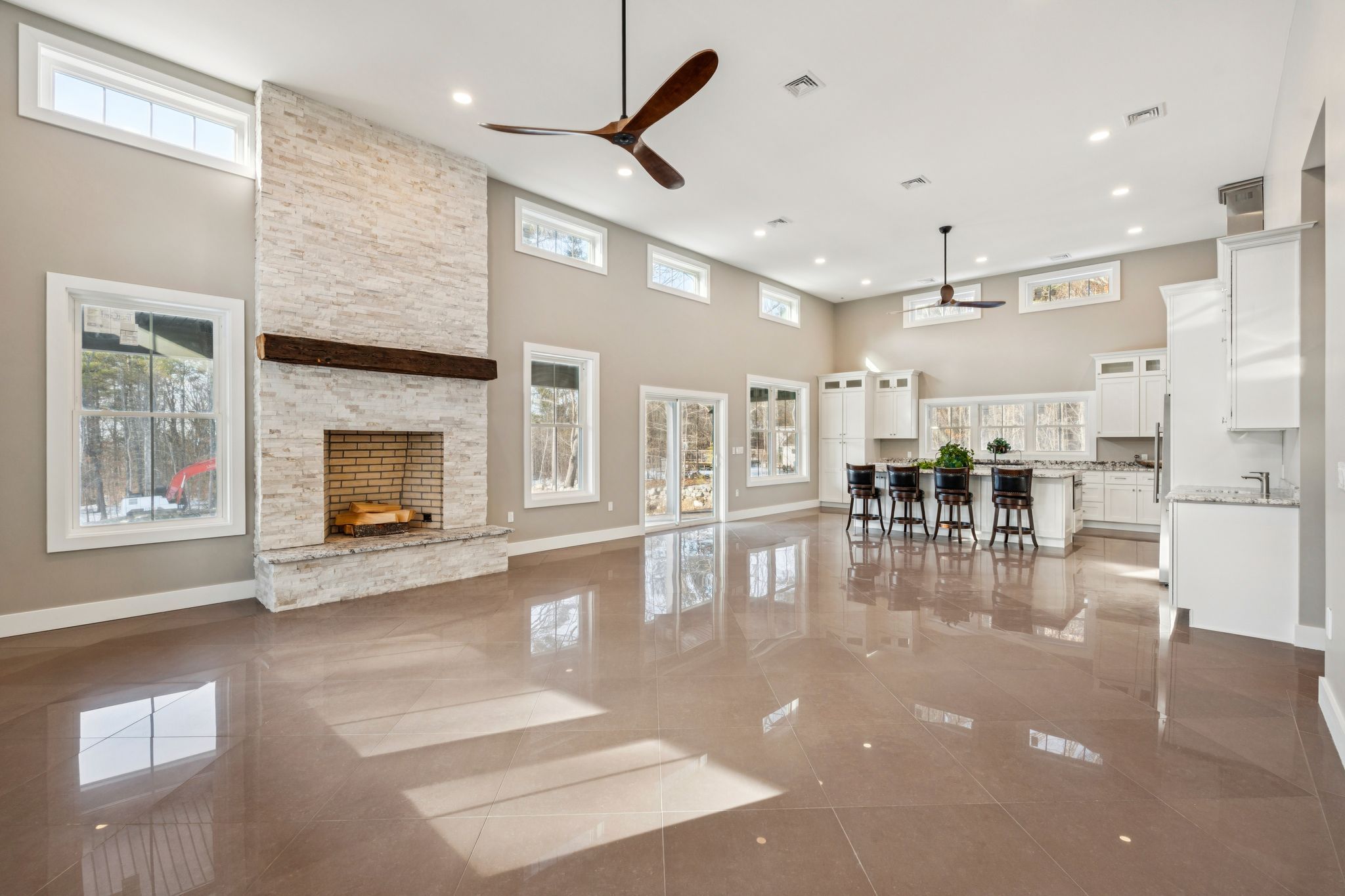 Spacious open-concept dining area and kitchen with hardwood floors, elegant chandelier, and a staircase leading to the upper level.