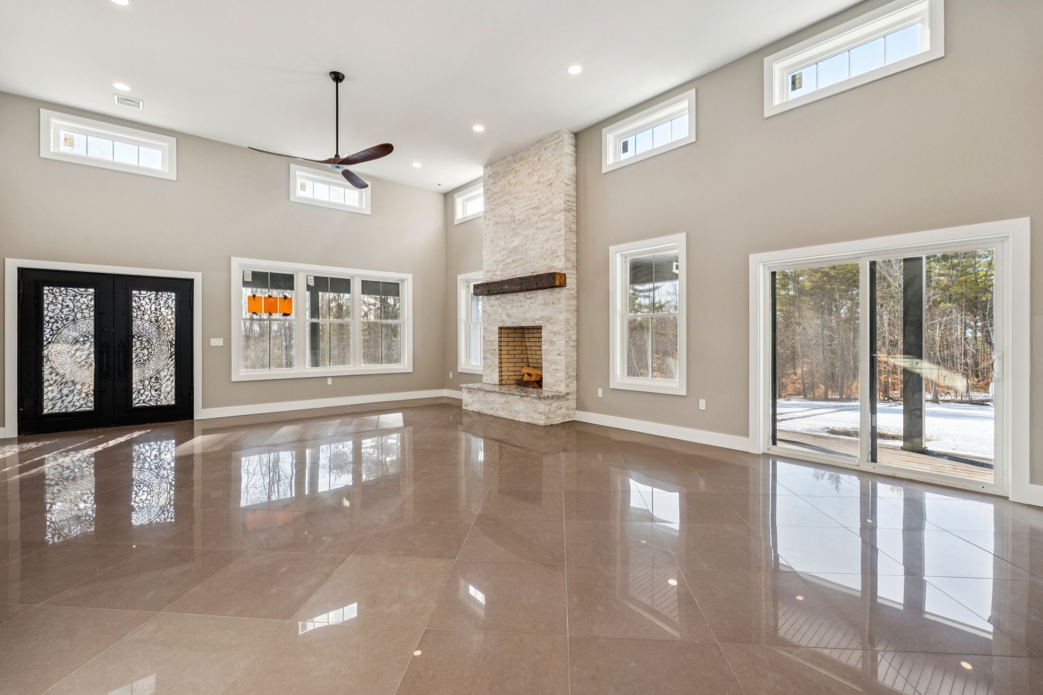 Modern white kitchen with granite countertops, stainless steel appliances, and hardwood flooring