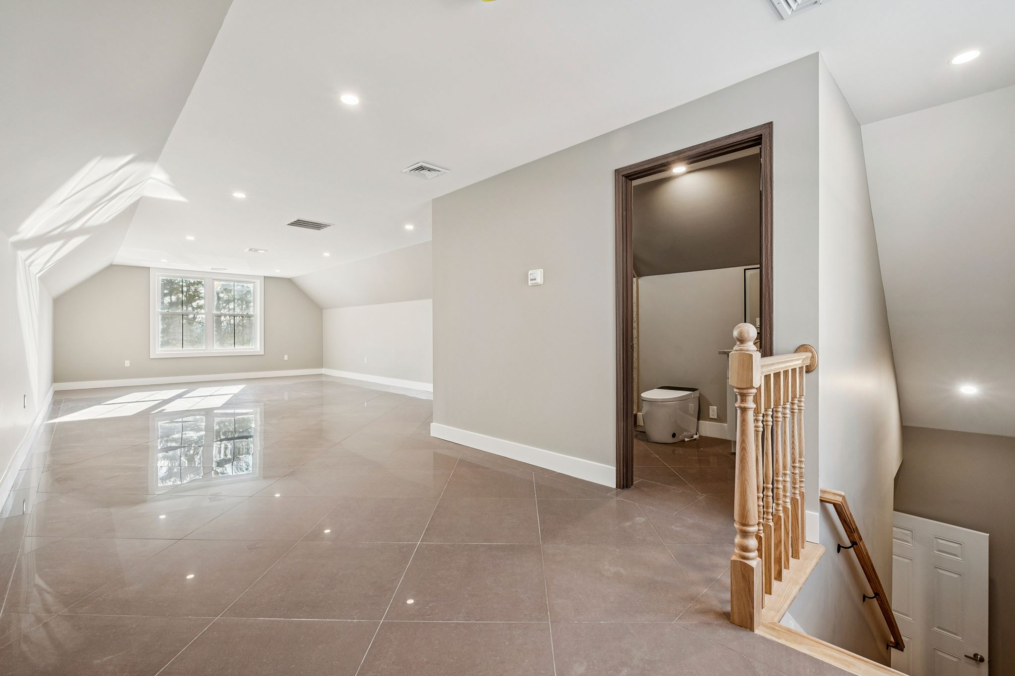 Modern kitchen with white cabinets, stainless steel stove, granite countertops, and hardwood flooring, decorated with a black and white checkered teapot and a vintage-style clock.