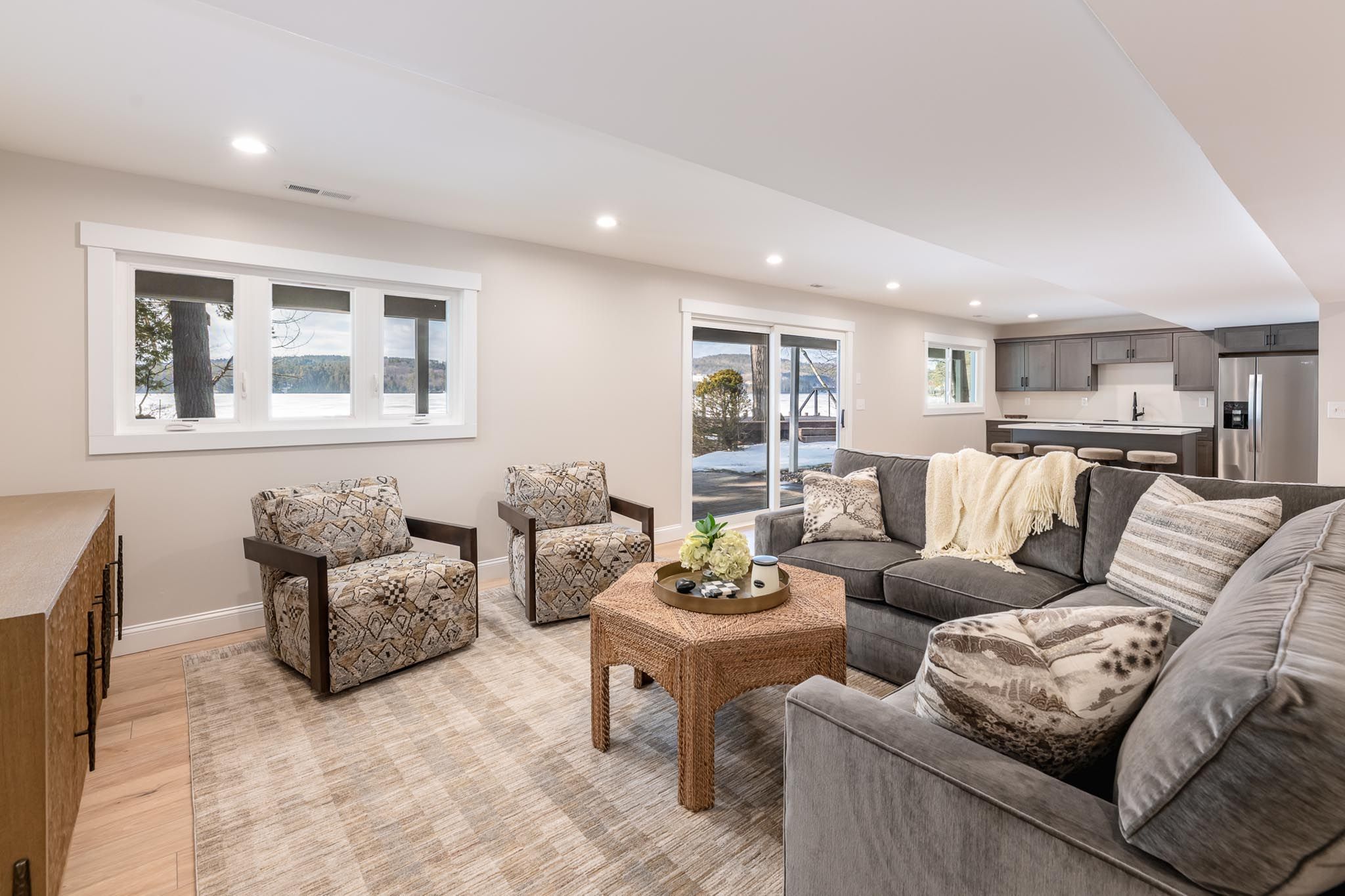 Private lakeside house with a boat dock and a boat cruising on calm water surrounded by lush green trees.