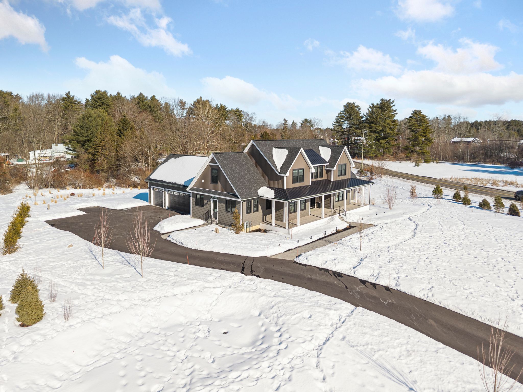 Snow-covered backyard with leafless trees and a clear blue sky during winter day