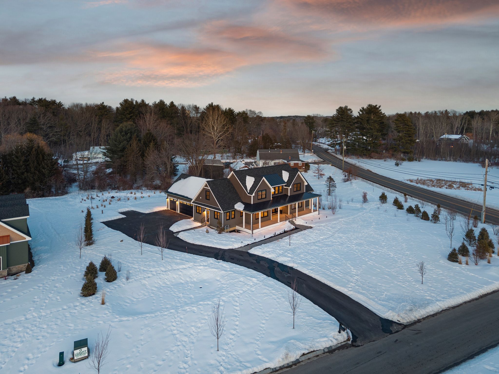 Snow-covered backyard with leafless trees and a clear blue sky during winter day