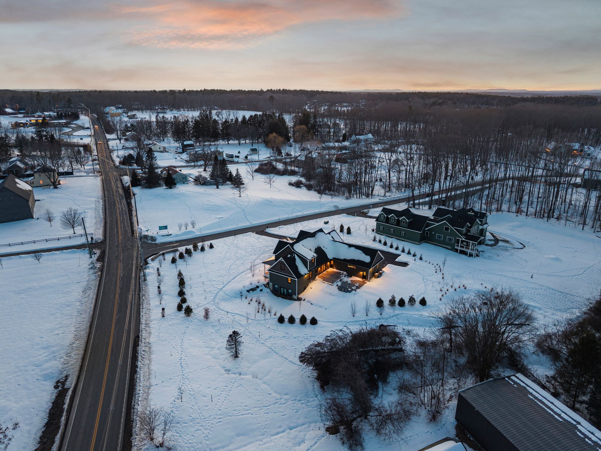 Snow-covered backyard with leafless trees and a clear blue sky during winter day