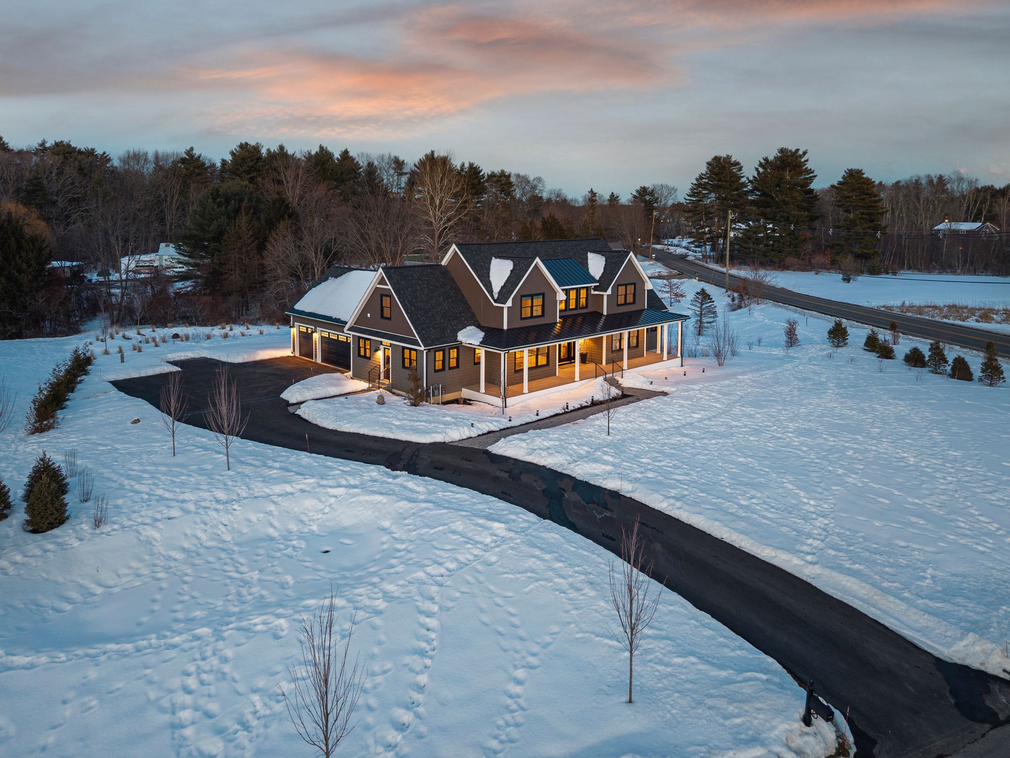 Snow-covered backyard with leafless trees and a clear blue sky during winter day