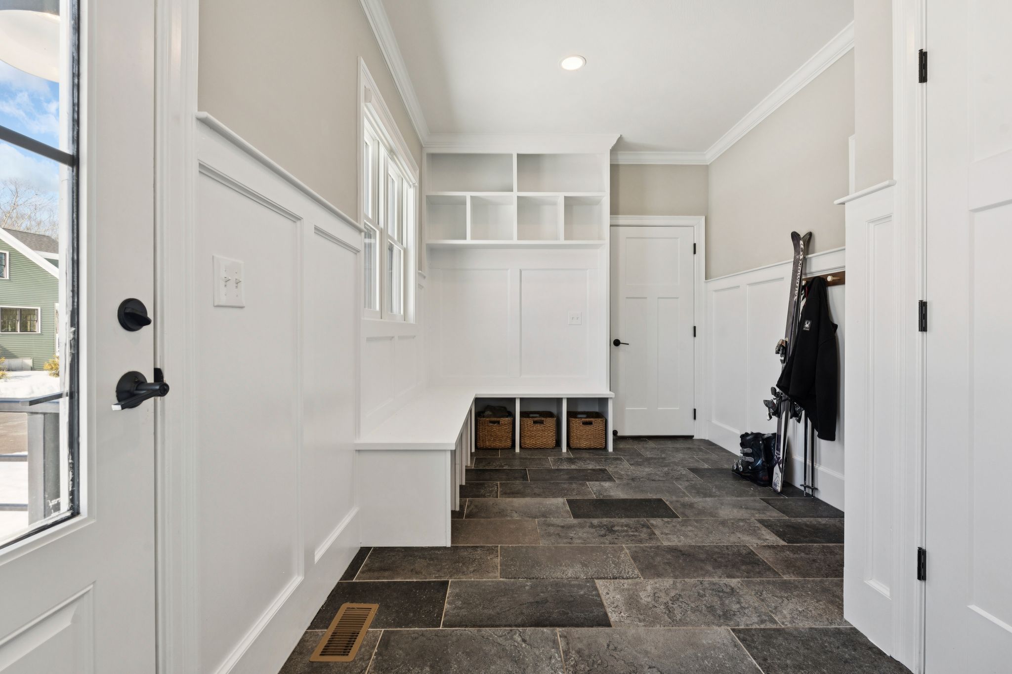 Snow-covered backyard with leafless trees and a clear blue sky during winter day