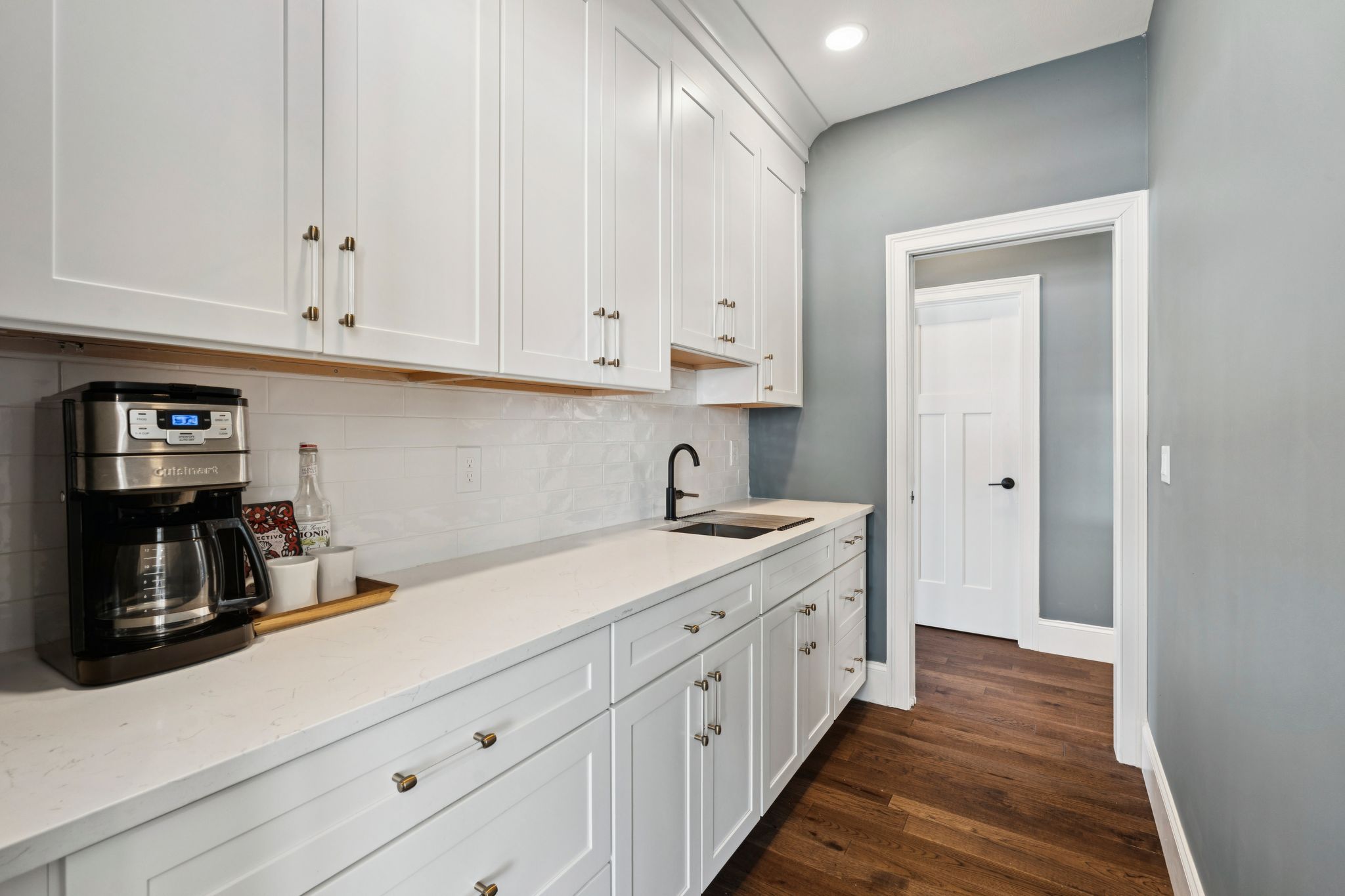 Snow-covered backyard with leafless trees and a clear blue sky during winter day
