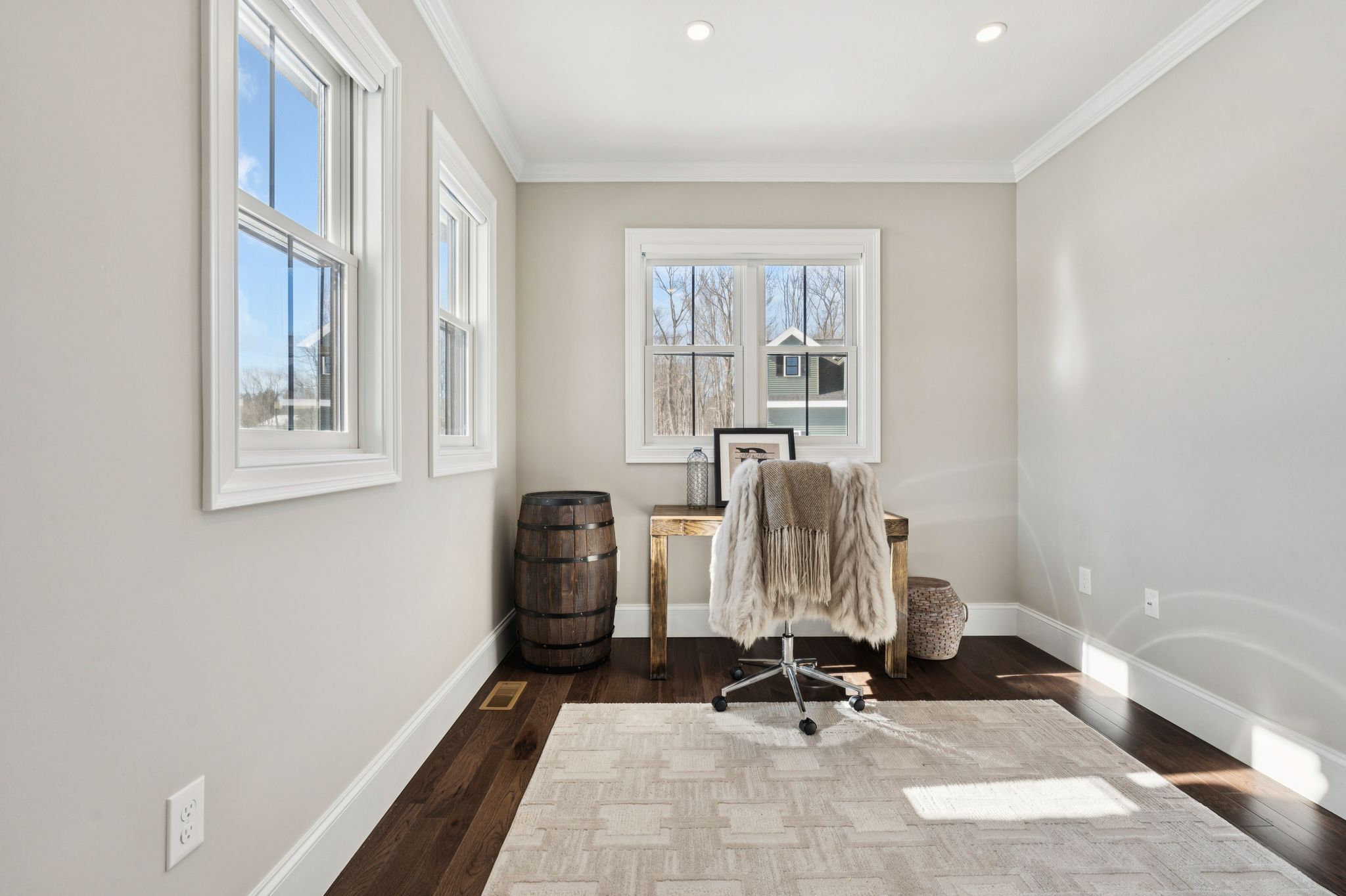Snow-covered backyard with leafless trees and a clear blue sky during winter day