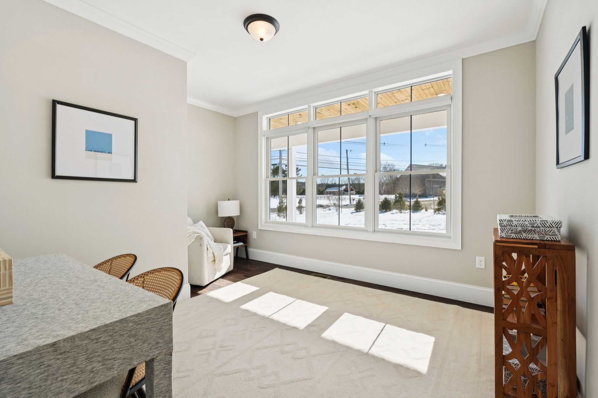 Snow-covered backyard with leafless trees and a clear blue sky during winter day