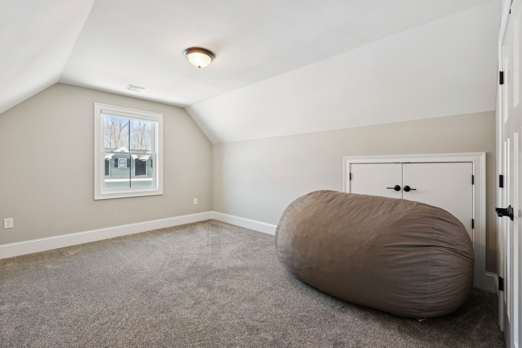 Snow-covered backyard with leafless trees and a clear blue sky during winter day