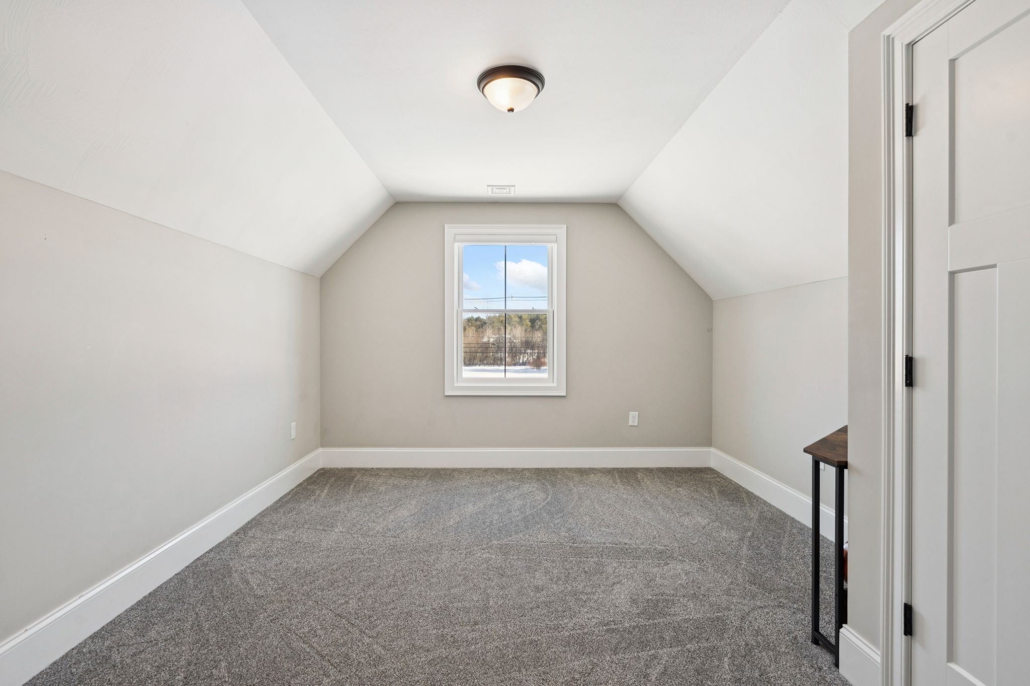 Snow-covered backyard with leafless trees and a clear blue sky during winter day