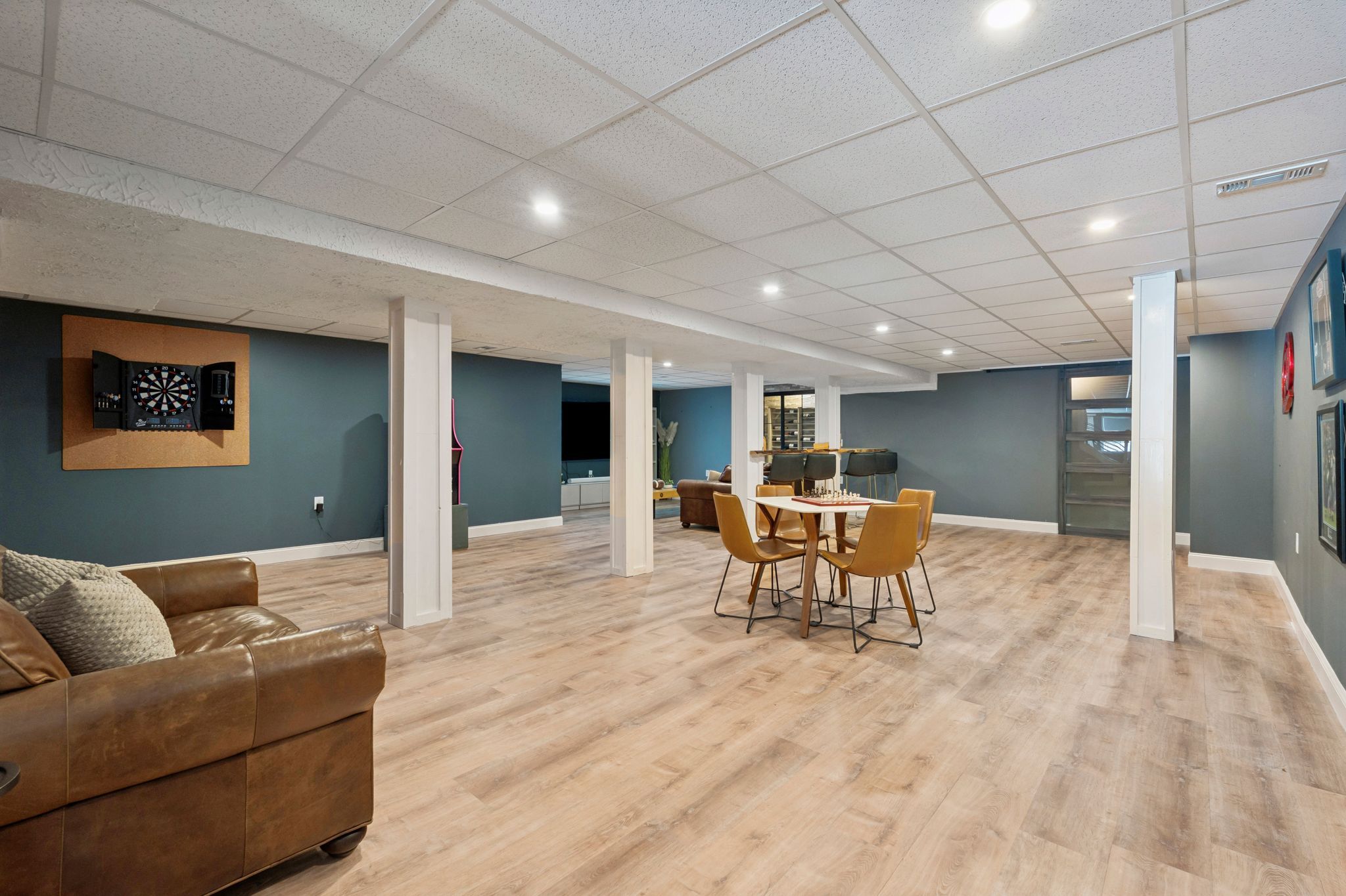 Snow-covered backyard with leafless trees and a clear blue sky during winter day