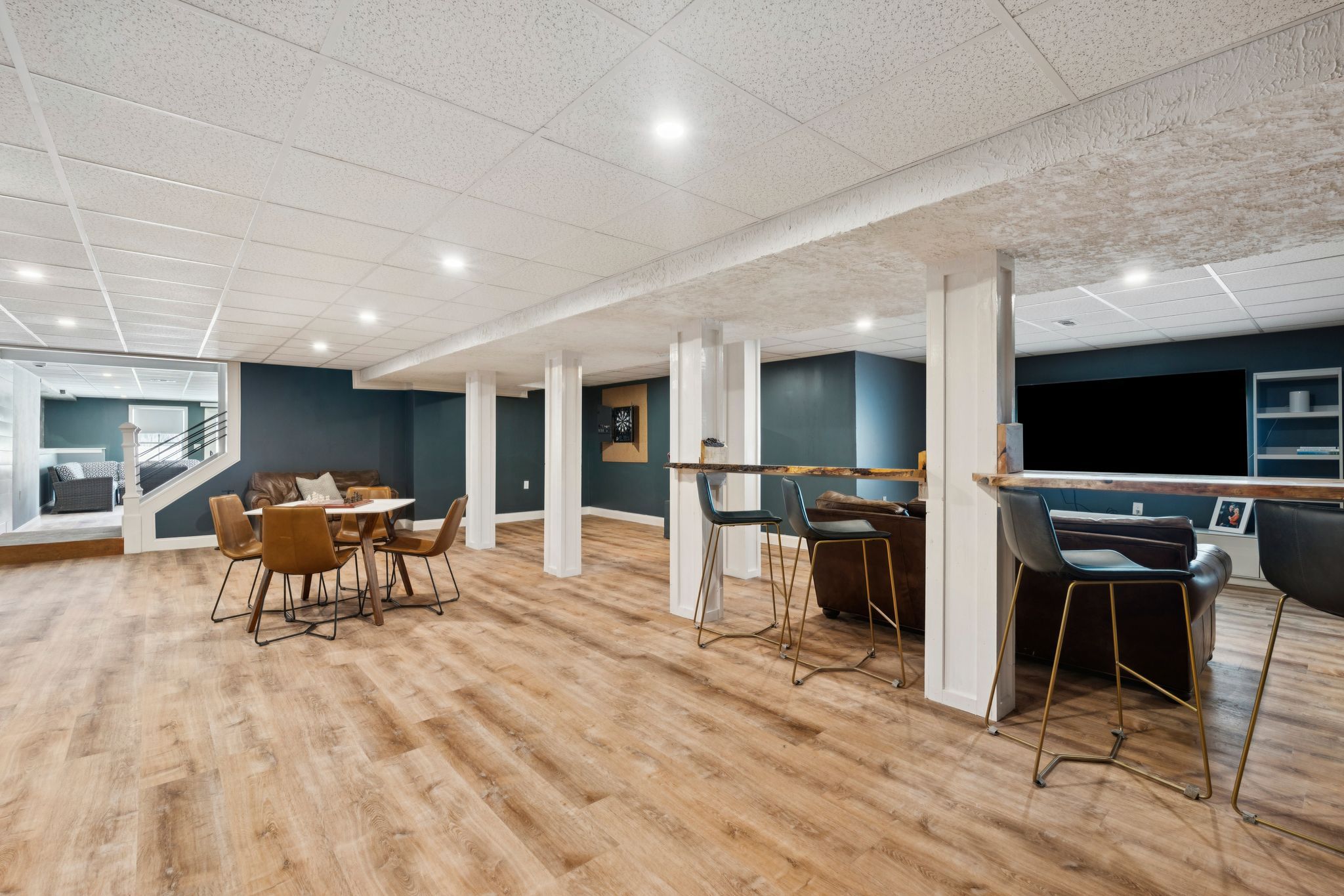 Snow-covered backyard with leafless trees and a clear blue sky during winter day
