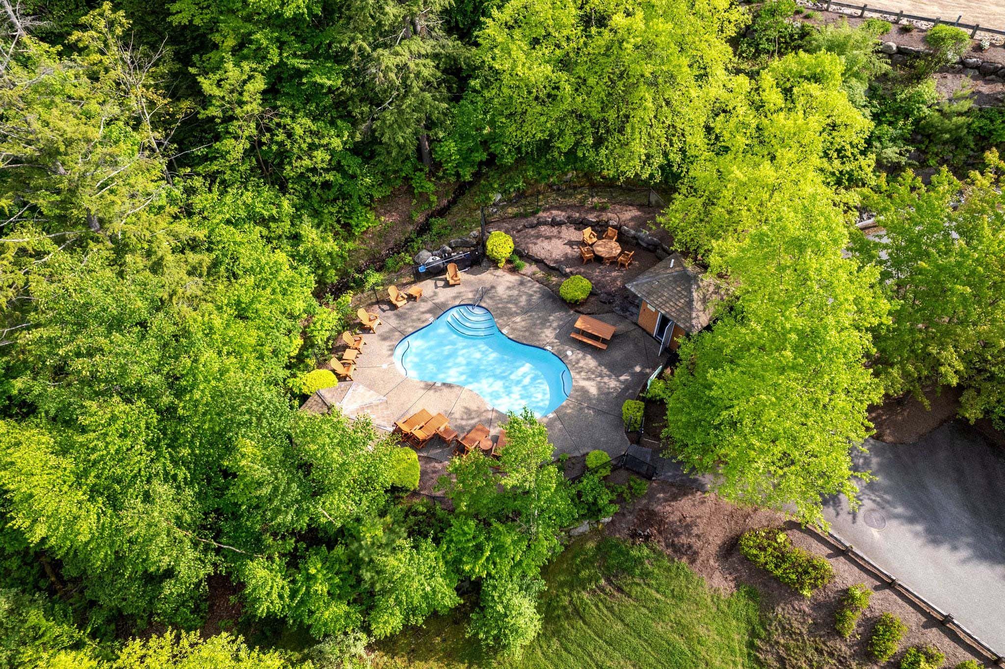 Spacious living room with large windows, high vaulted ceiling, cozy seating area, and modern decor in a bright, open-concept home.