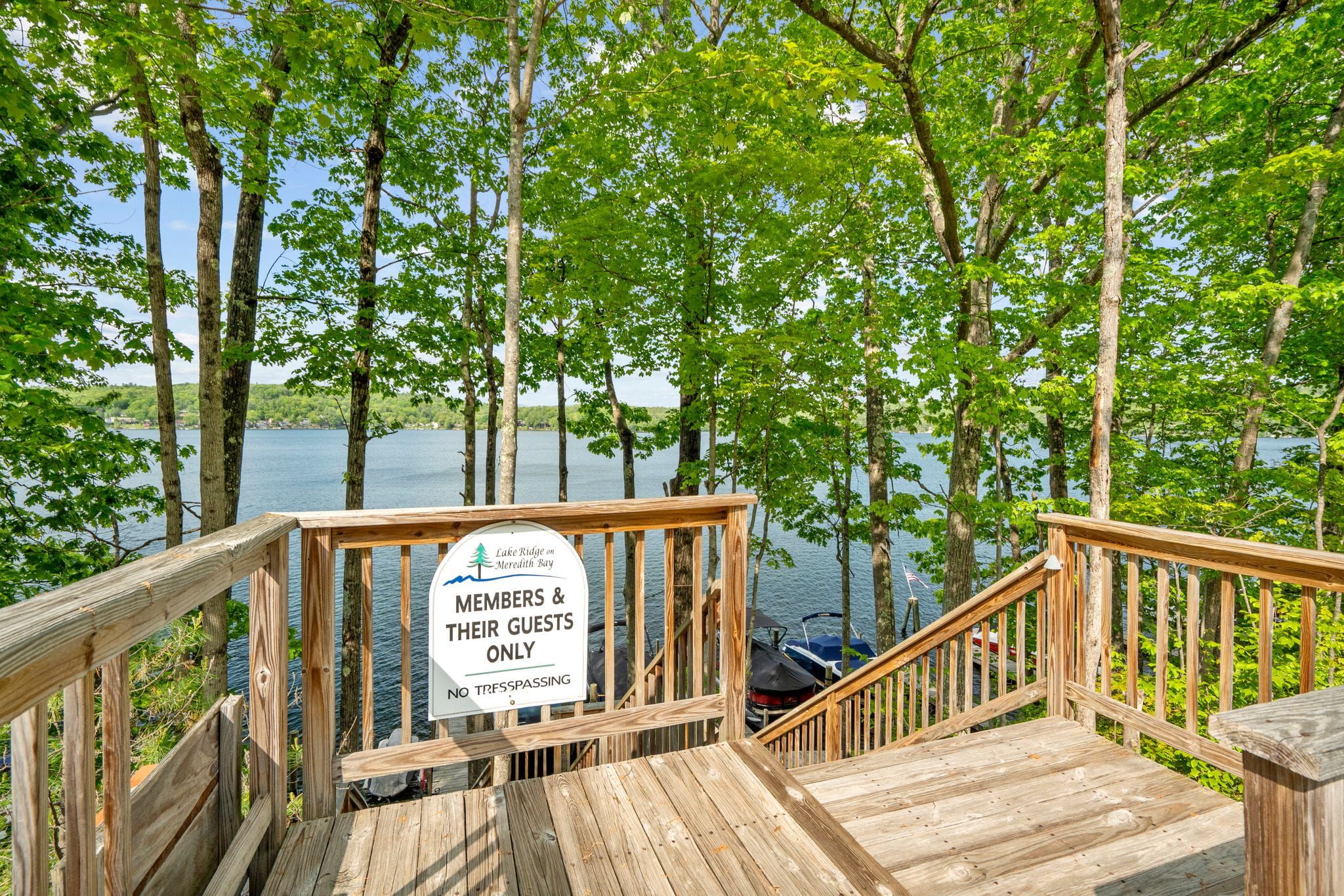 Interior view of a white front entryway with a decorative door featuring a stained glass wreath design, and a white built-in coat rack with hooks and storage space for shoes and accessories.