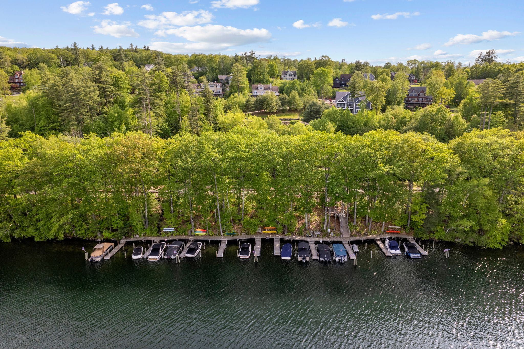Spacious open-concept living room with high vaulted ceilings, large windows, contemporary furniture, area rugs, and modern décor.