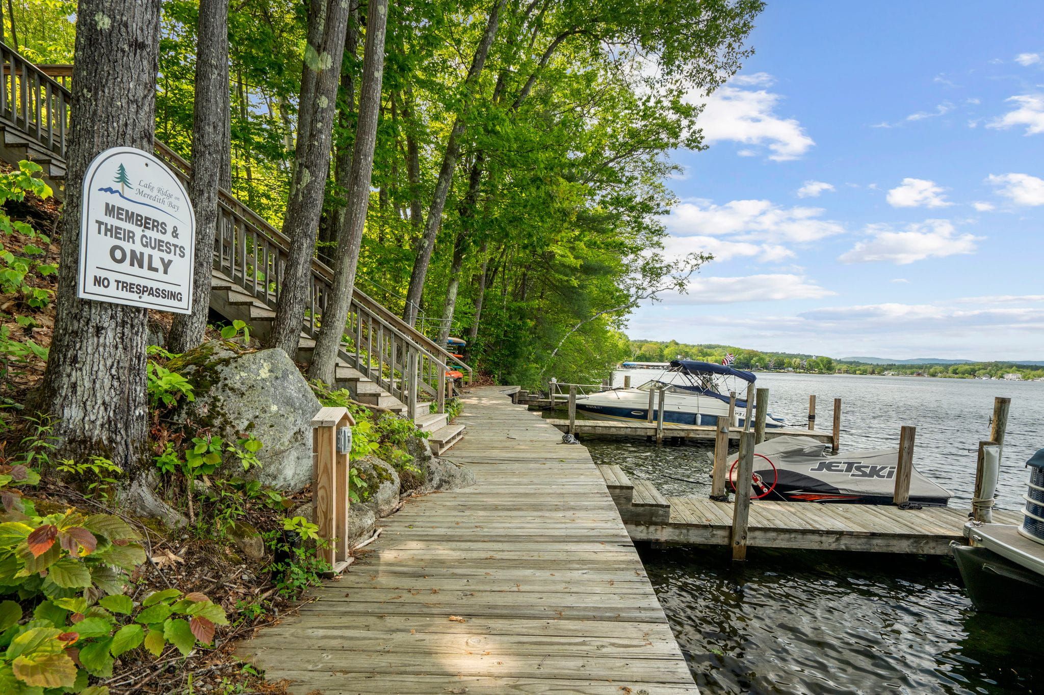Modern kitchen with granite countertop, farmhouse sink, stainless steel faucet, and view of bright living room with large windows and greenery.
