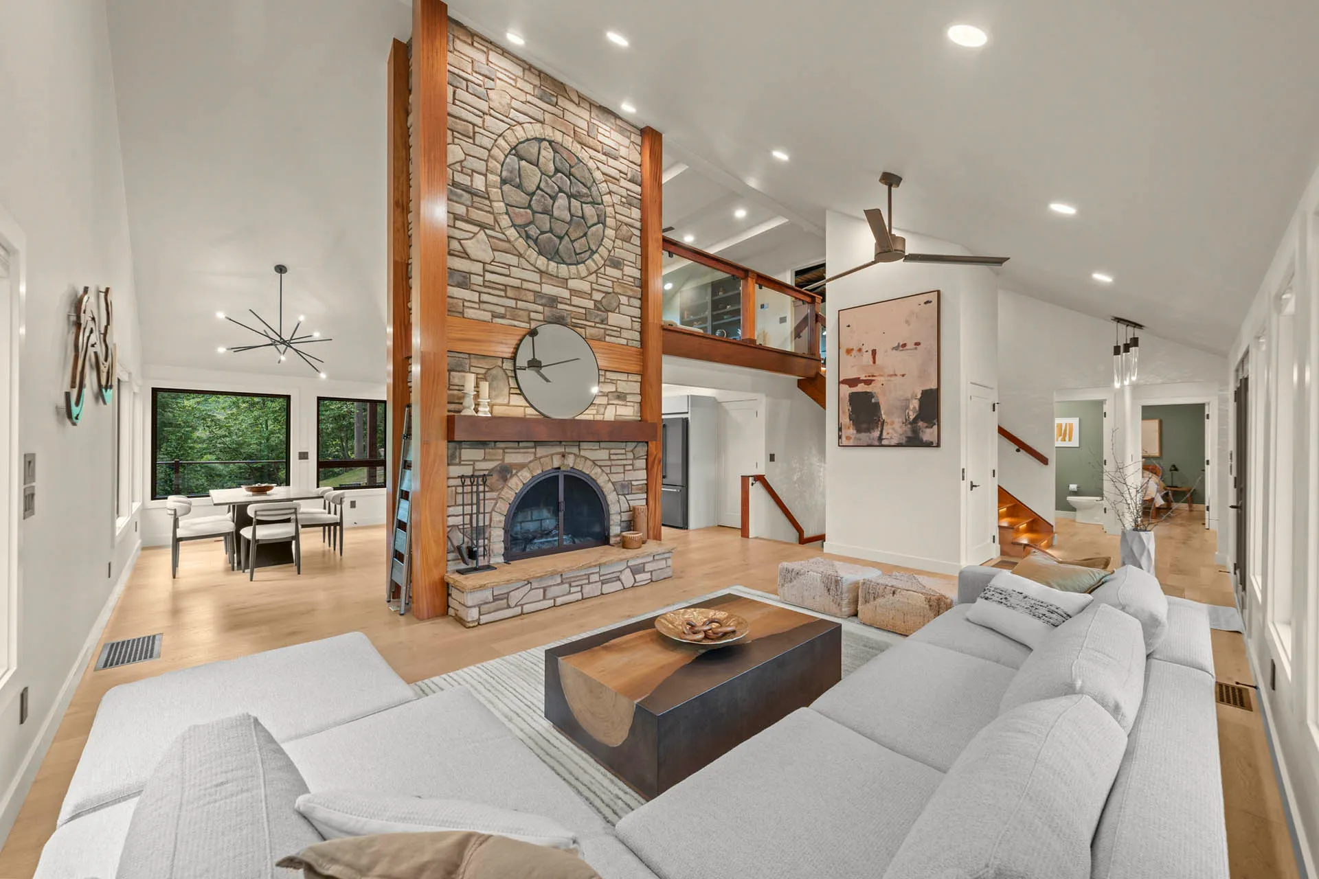 Living room with a stone fireplace, high ceiling, and sectional seating at 6915 Eagle Rd