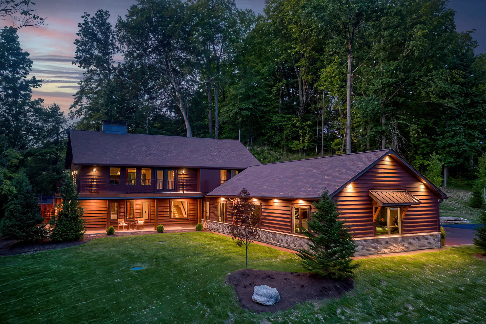 Dusk view of the 6915 Eagle Rd home surrounded by mature trees