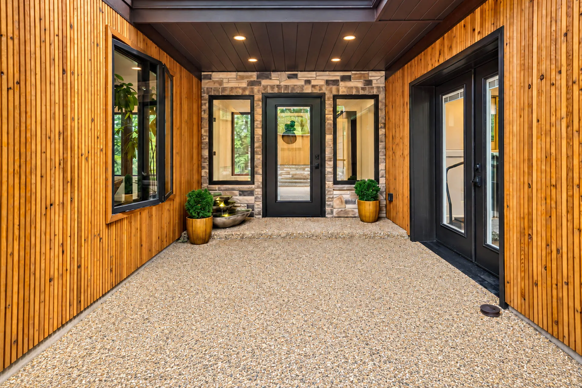 Covered front entry with stone walls and a wood ceiling at 6915 Eagle Rd