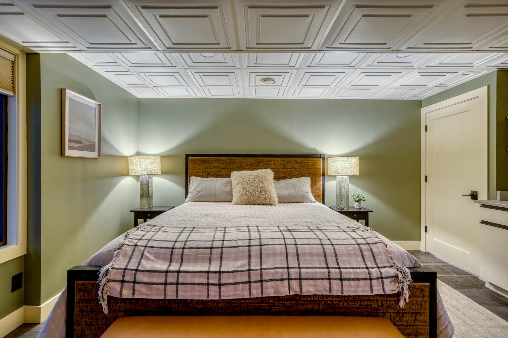 Bedroom with plaid bedding, wood headboard, and bedside lamps at 6915 Eagle Rd