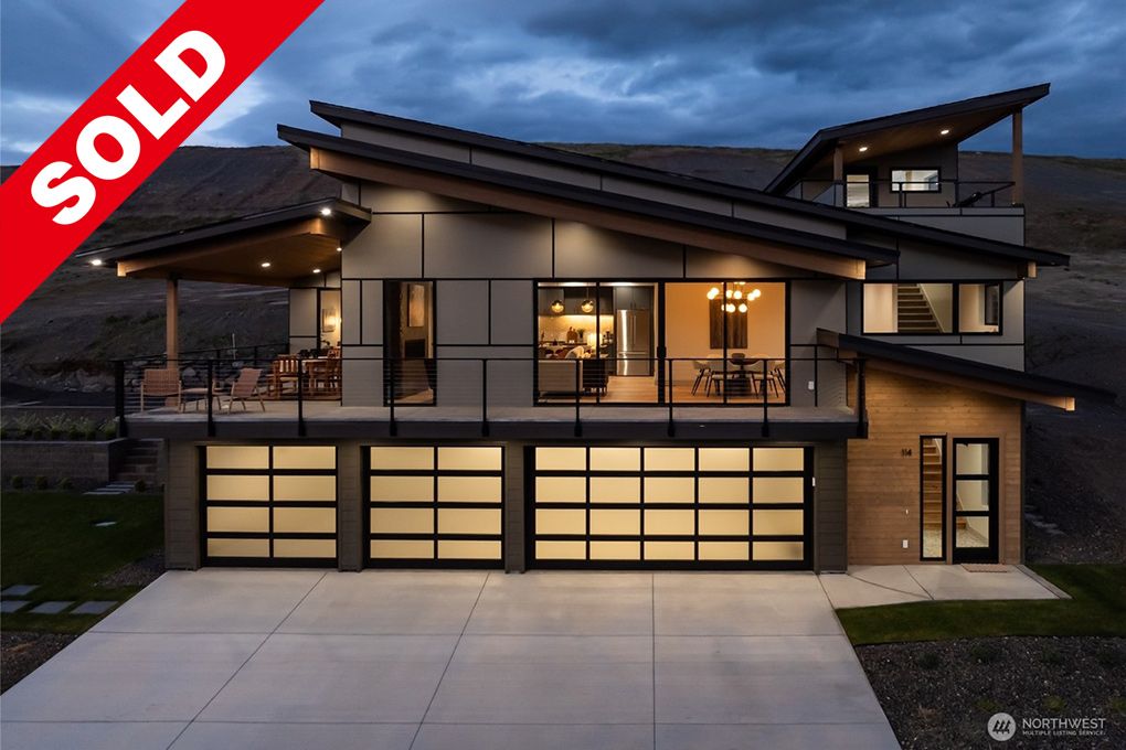 Modern house interior and balcony with scenic mountain view, sold property, open-plan dining and living area with large windows, contemporary decor, and stylish lighting.