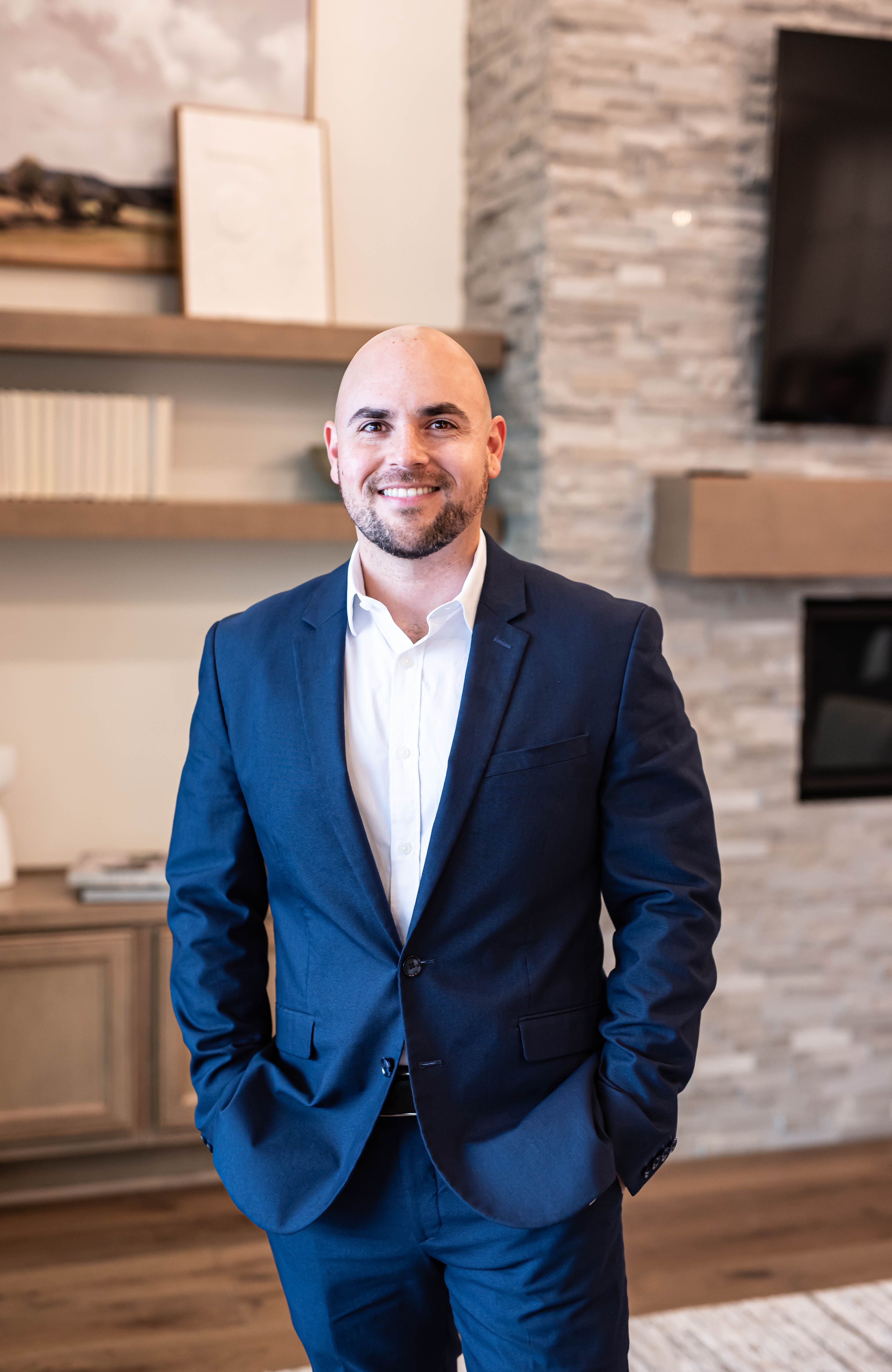 Portrait of a smiling male realtor in a navy suit and white shirt, awarded 