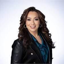 Friendly female realtor smiling at camera with 