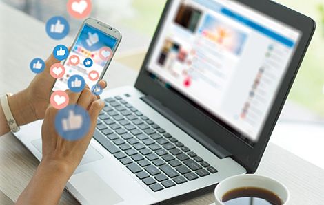 person using a phone and a laptop