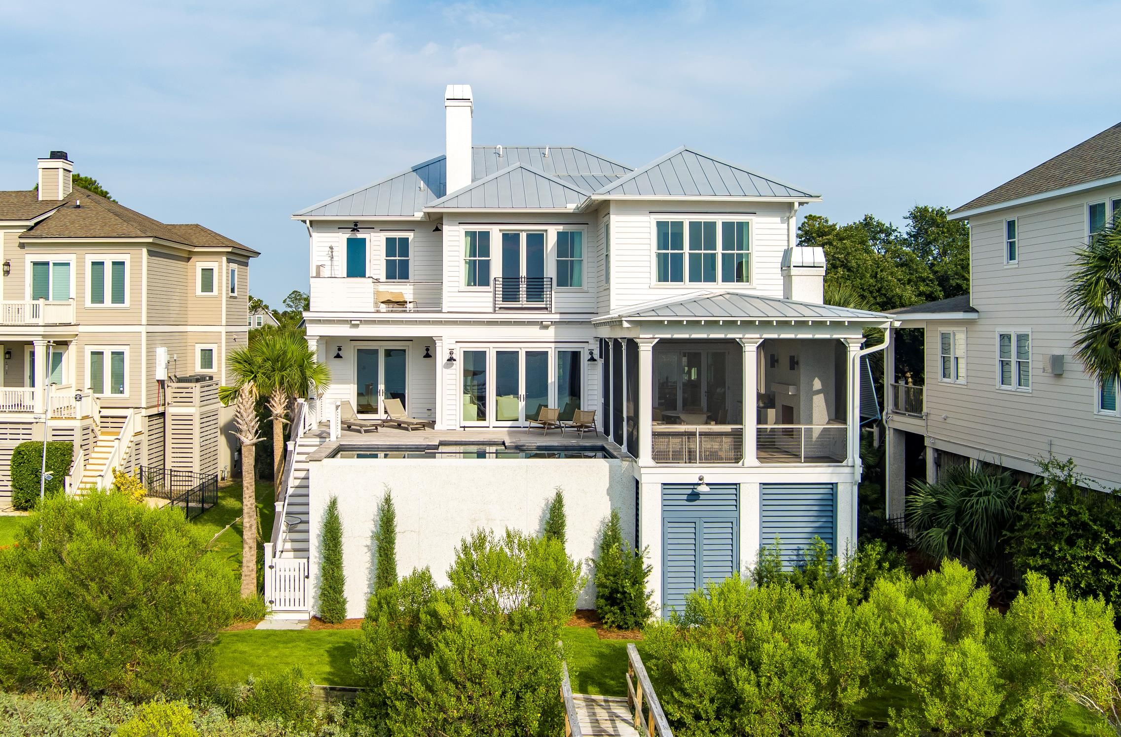 Nighttime cityscape with illuminated modern office buildings, historic church, and parking lot filled with cars, surrounded by green trees.