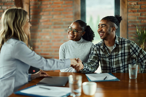 couple shaking hands with agent