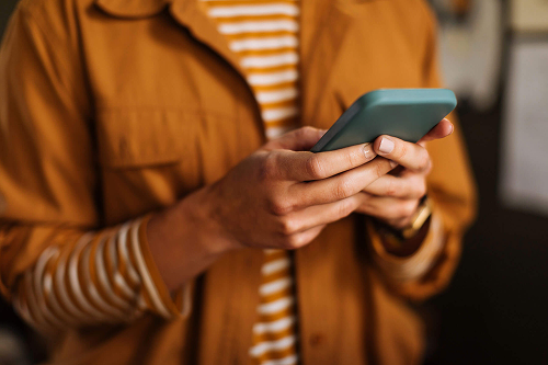 person in yellow outfit using phone