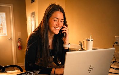person smiling looking at her laptop