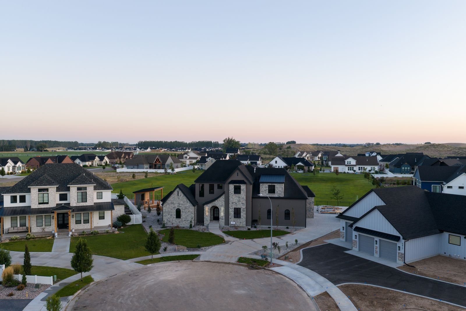 Aerial view of a stone two-story Valhalla Homes custom home in an Idaho Falls-area neighborhood