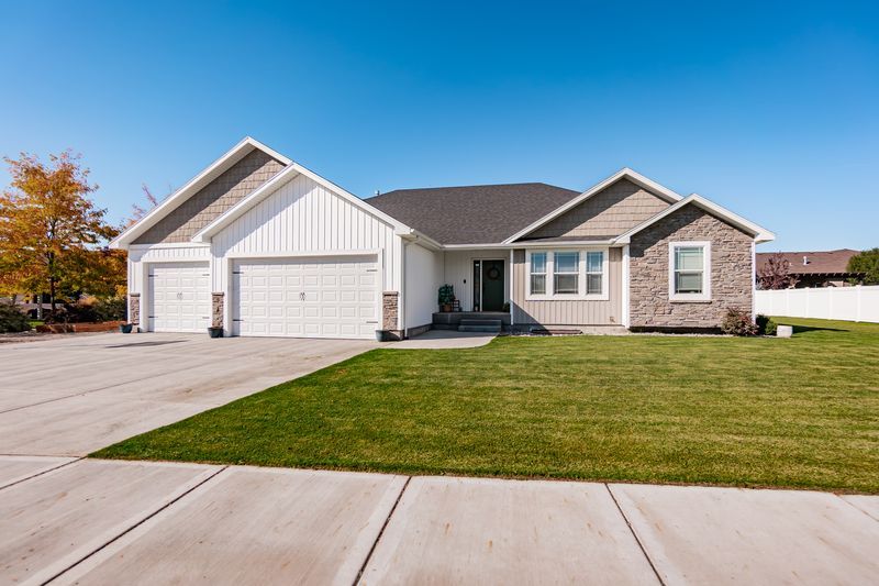 Single-story Vantage Point Homes house with stone accents and a three-car garage in the Idaho Falls area