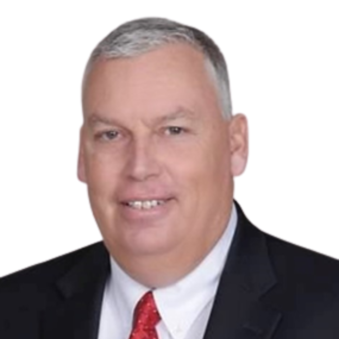 Smiling middle-aged woman with short blonde hair wearing a blue blazer and a black top, against a white background.